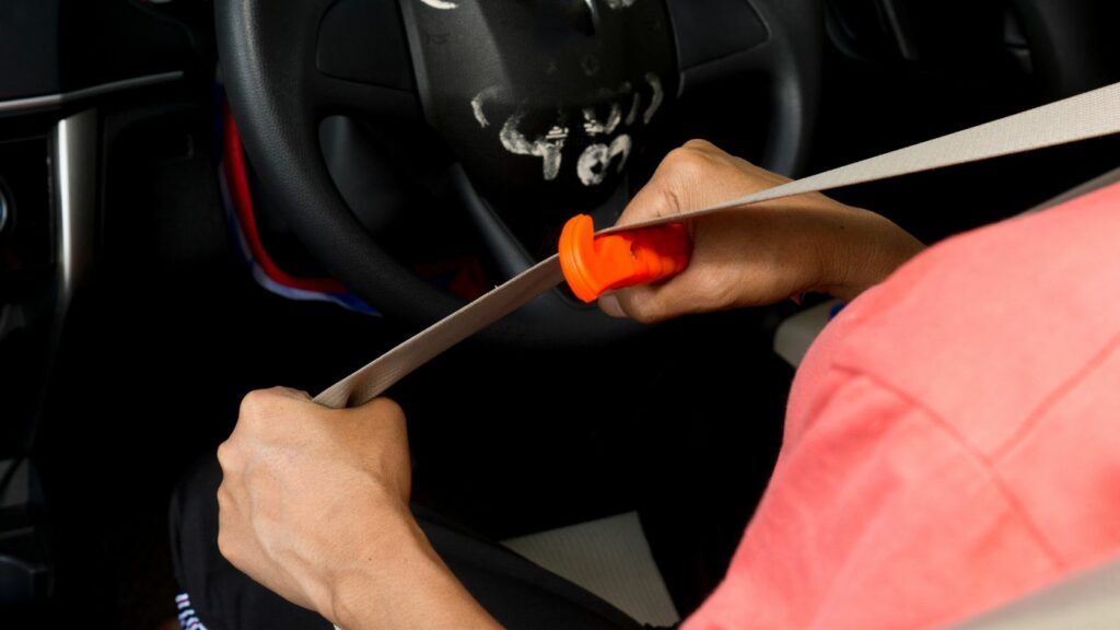 Cutting a seat belt with a car emergency escape tool